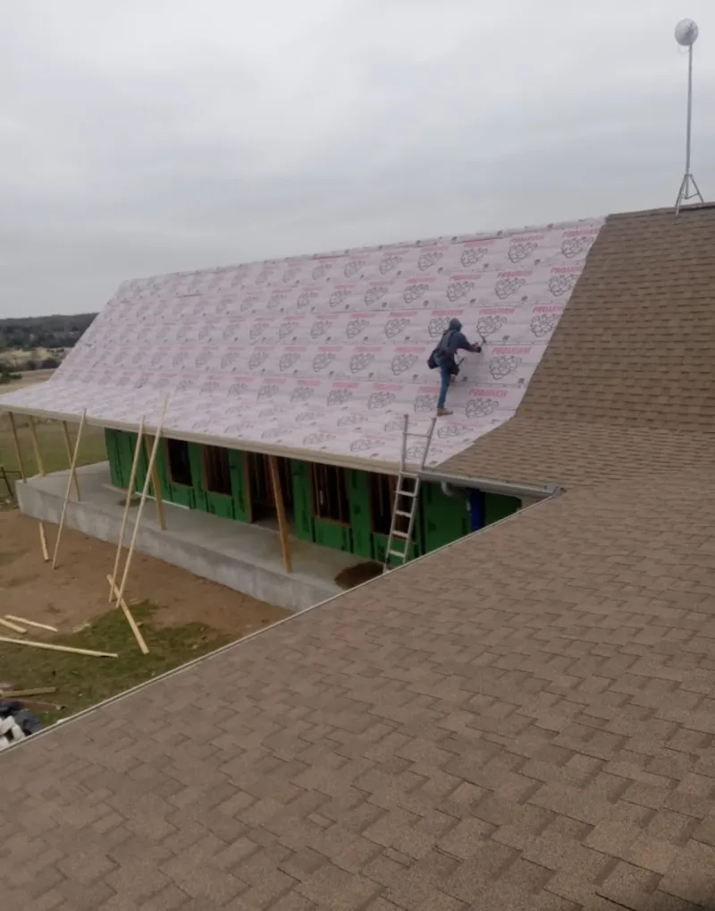 Worker preparing underlayment for a metal roof installation in Travilah